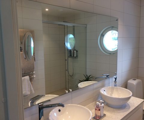 Spegel och duschvägg i glas i badrum